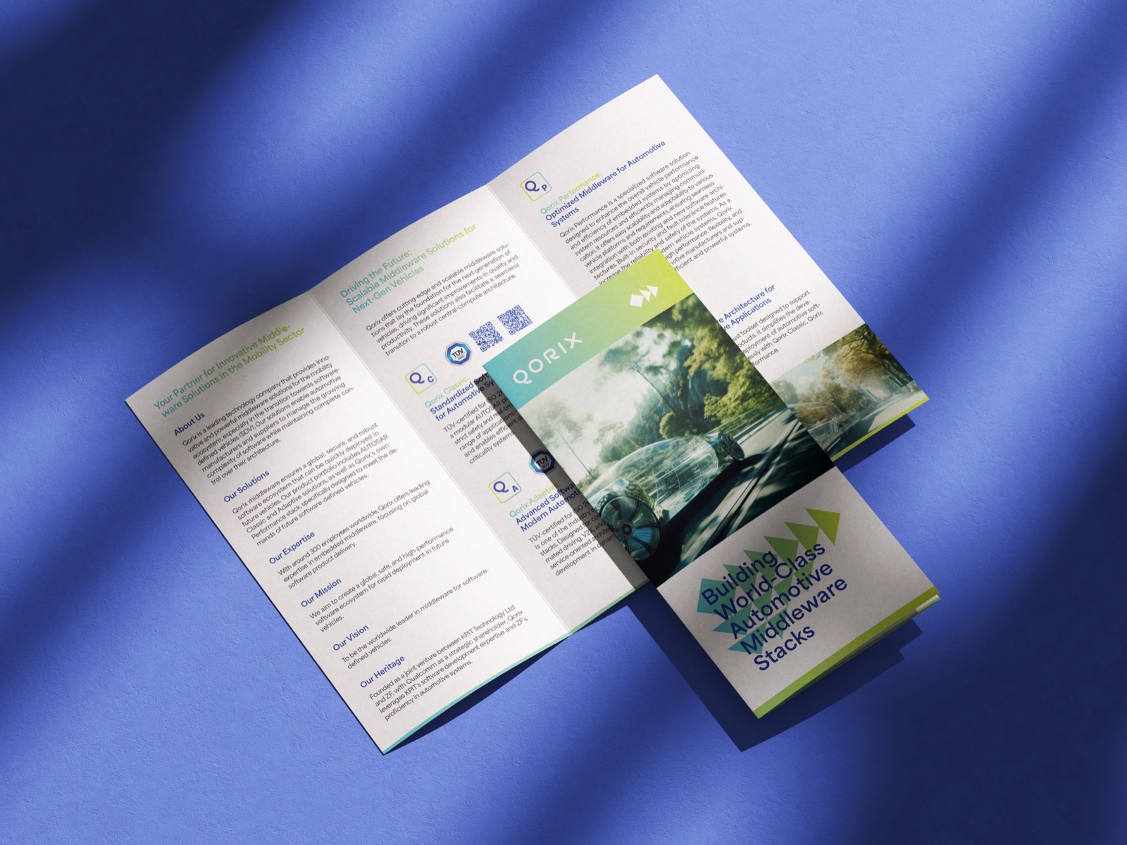 Aufgeklapptes Faltblatt mit Titelseite auf blauem Untergrund — Qorix, laufende Designbetreuung