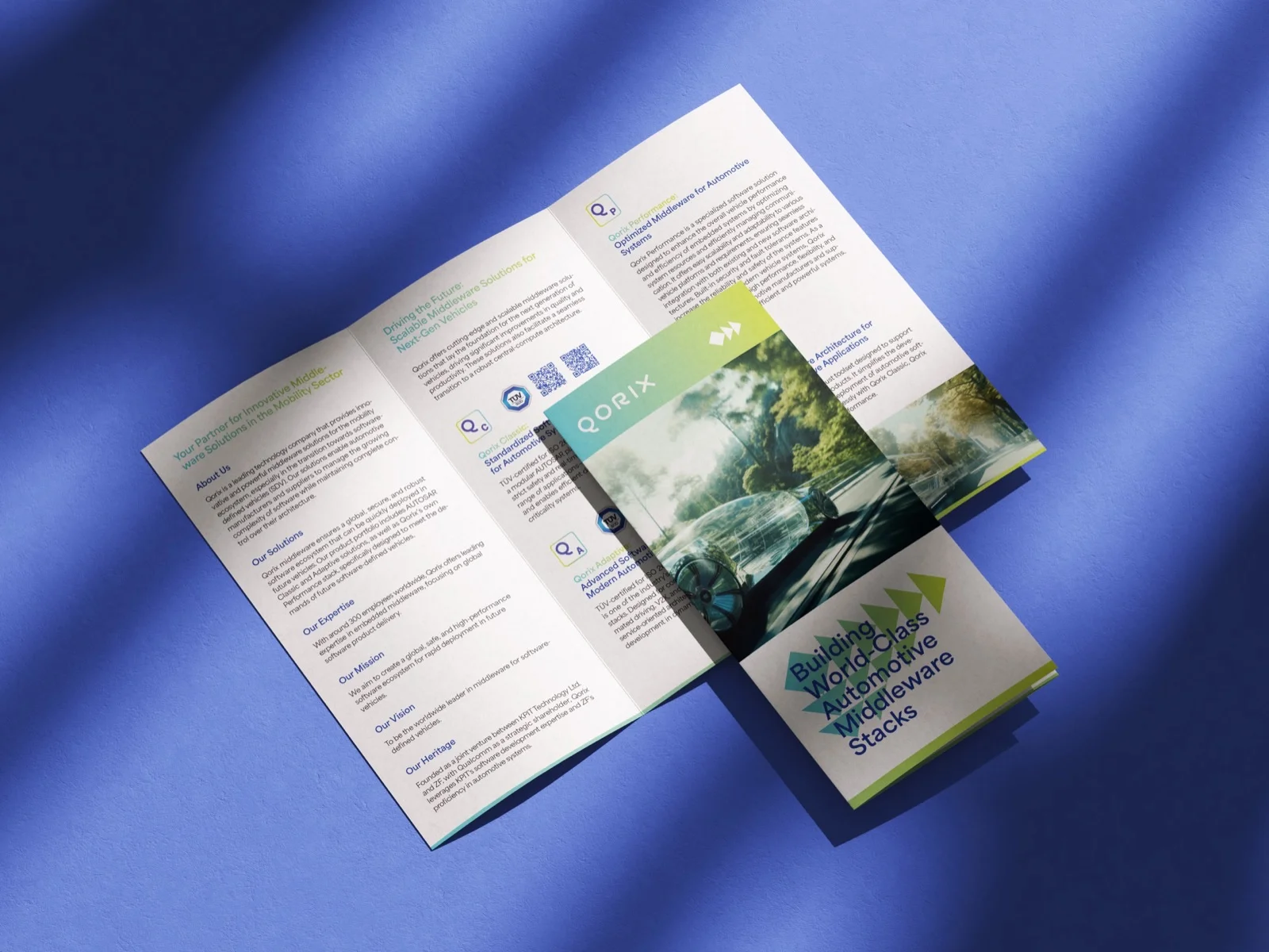 Aufgeklapptes Faltblatt mit Titelseite auf blauem Untergrund — Qorix, laufende Designbetreuung